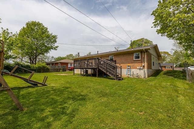 rear view of property with fence, stairs, brick siding, a deck, and a yard
