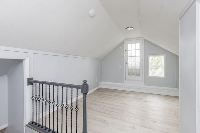 bonus room featuring baseboards, vaulted ceiling, and wood finished floors