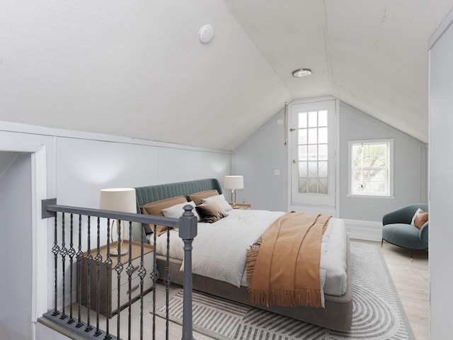 bedroom with lofted ceiling and wood finished floors