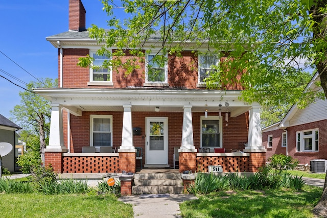 view of front of property with brick siding, covered porch, a chimney, and cooling unit