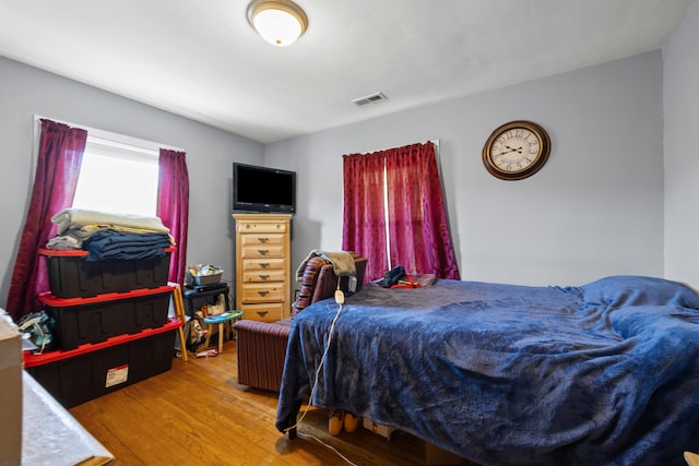 bedroom with visible vents and wood finished floors