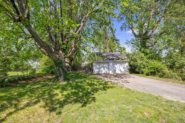 view of yard featuring an outdoor structure, a garage, and fence