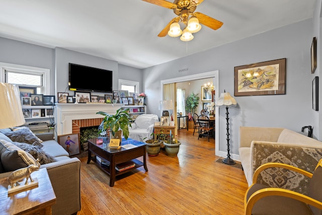 living area featuring a ceiling fan, light wood finished floors, and a healthy amount of sunlight