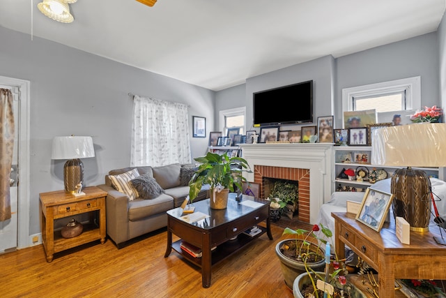 living area featuring plenty of natural light, wood finished floors, and a fireplace