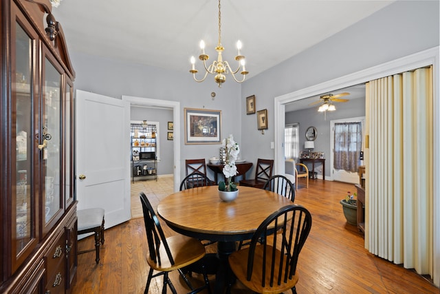 dining room featuring wood finished floors and ceiling fan with notable chandelier