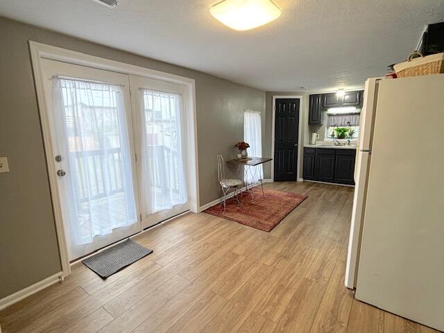 doorway with light wood finished floors and baseboards