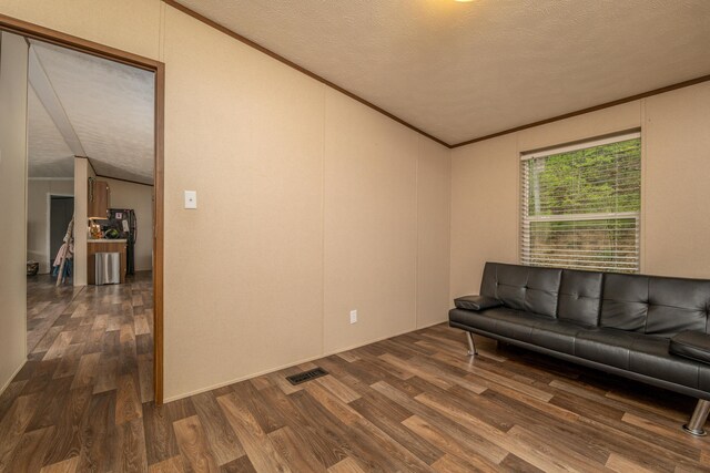 1132 State Highway 1662, Olive Hill, KY 41164 - living area with lofted ceiling, wood finished floors, a textured ceiling, visible vents, and crown molding