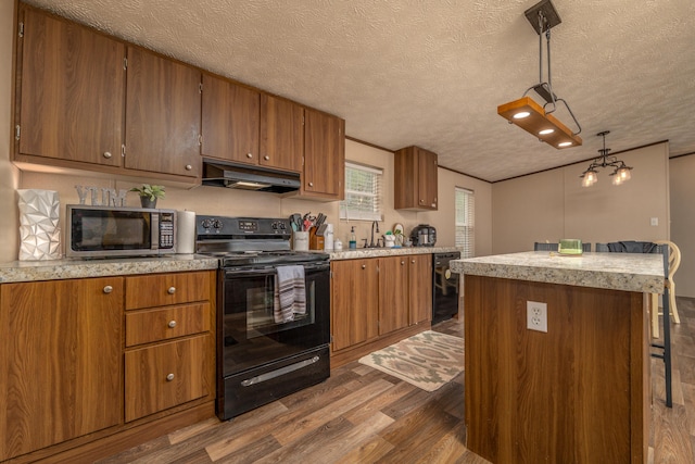 1132 State Highway 1662, Olive Hill, KY 41164 - kitchen with under cabinet range hood, dark wood-style flooring, brown cabinets, and black appliances