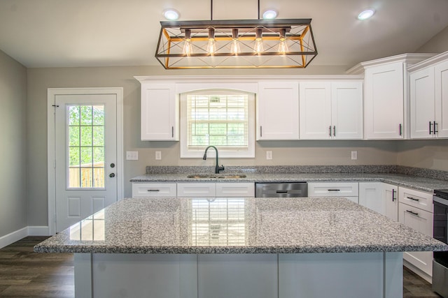 kitchen with stainless steel dishwasher, white cabinetry, a sink, dark wood-style floors, and a center island