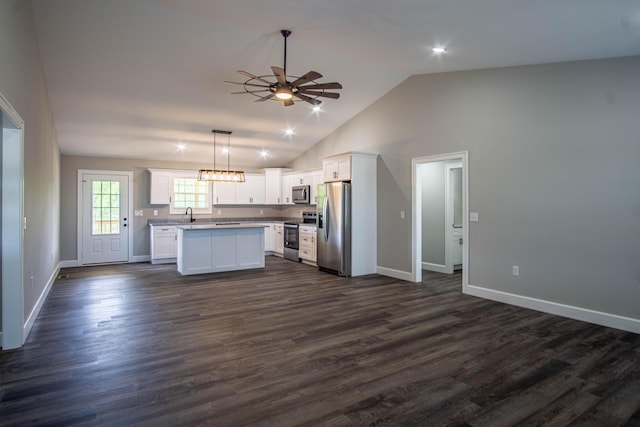 kitchen with appliances with stainless steel finishes, open floor plan, a ceiling fan, and white cabinets