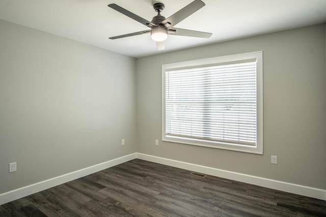 empty room with ceiling fan, visible vents, dark wood-style floors, and baseboards
