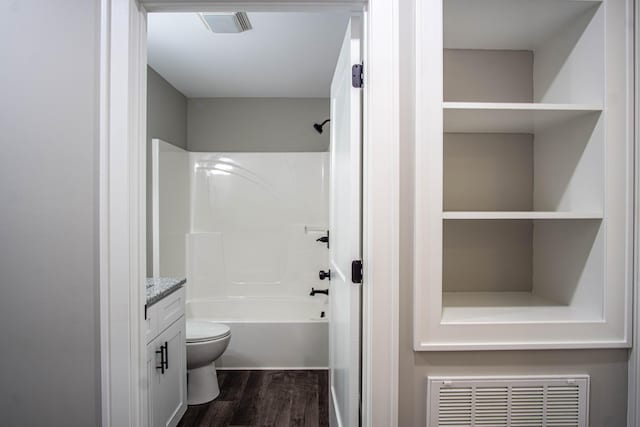 bathroom with wood finished floors, toilet, vanity, visible vents, and tub / shower combination
