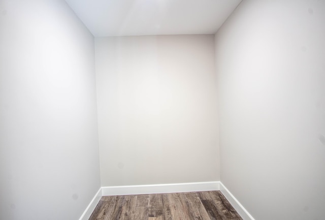 empty room with baseboards and dark wood-style flooring