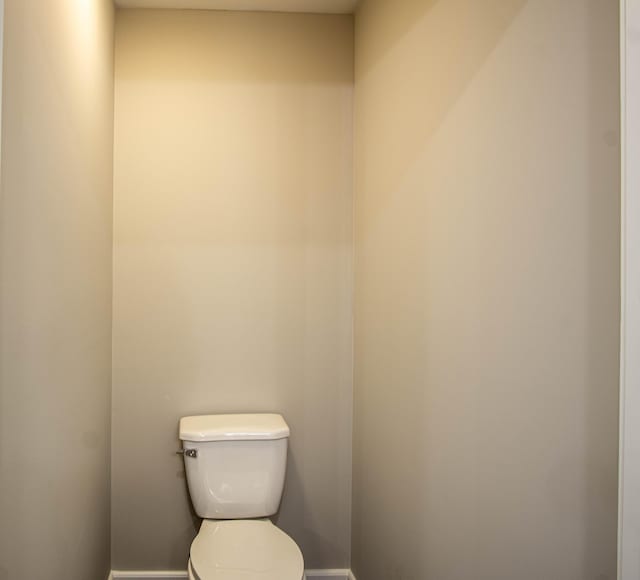 bathroom with baseboards and toilet