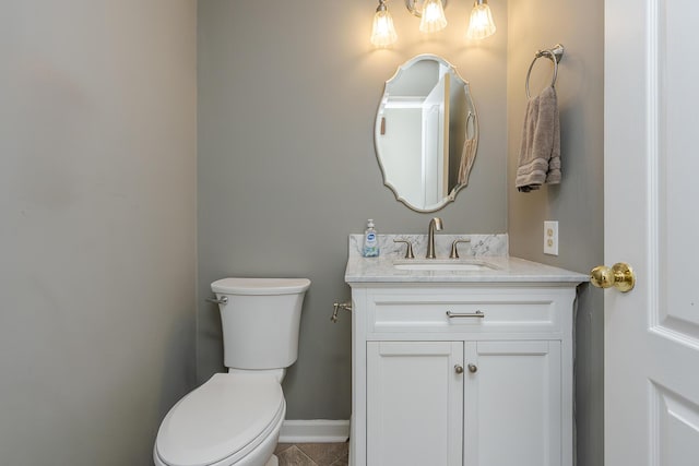 bathroom with vanity, toilet, tile patterned flooring, and baseboards