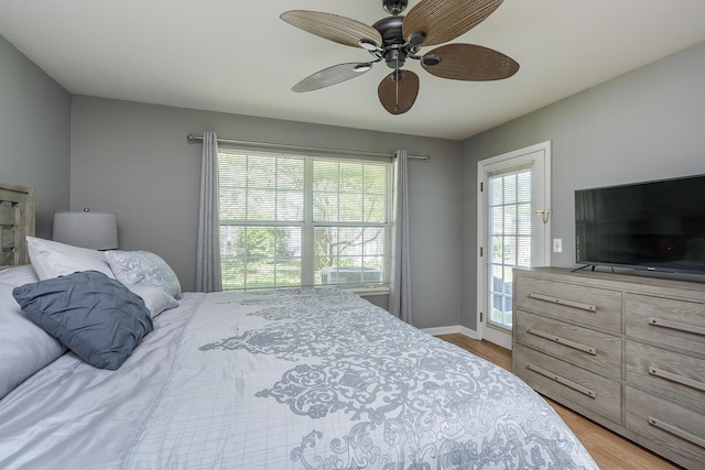 bedroom with wood finished floors, a ceiling fan, and baseboards