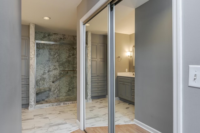 full bathroom featuring marble finish flooring, a stall shower, vanity, recessed lighting, and baseboards