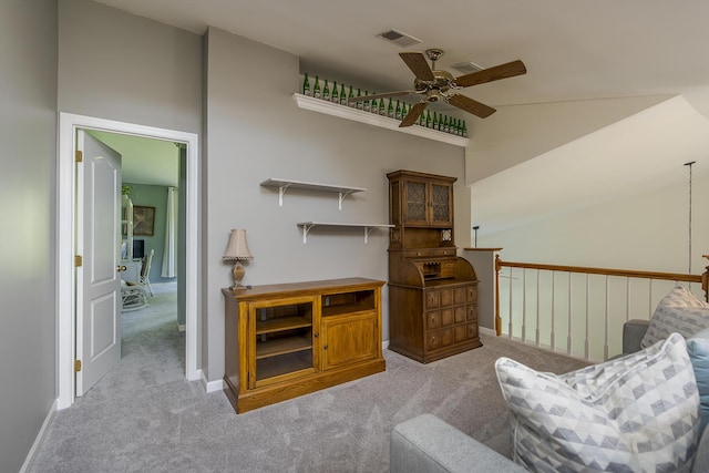 sitting room featuring light carpet, a ceiling fan, vaulted ceiling, and baseboards