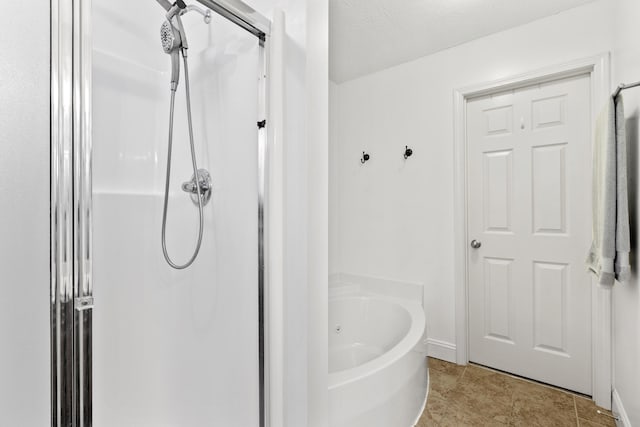 bathroom featuring tile patterned floors, an enclosed shower, a washtub, and baseboards