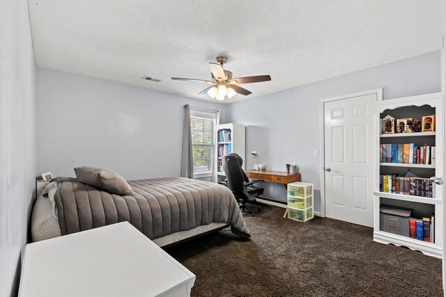bedroom featuring a textured ceiling, ceiling fan, dark colored carpet, and visible vents