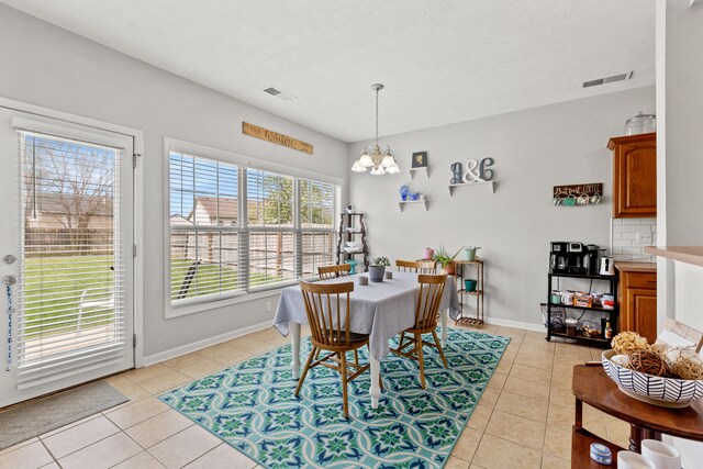 dining space featuring visible vents, light tile patterned floors, and a notable chandelier
