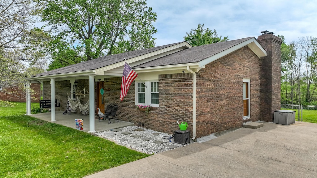 120 Grant Dr, Richmond, KY 40475 - exterior space with a chimney, fence, a yard, a patio, and brick siding