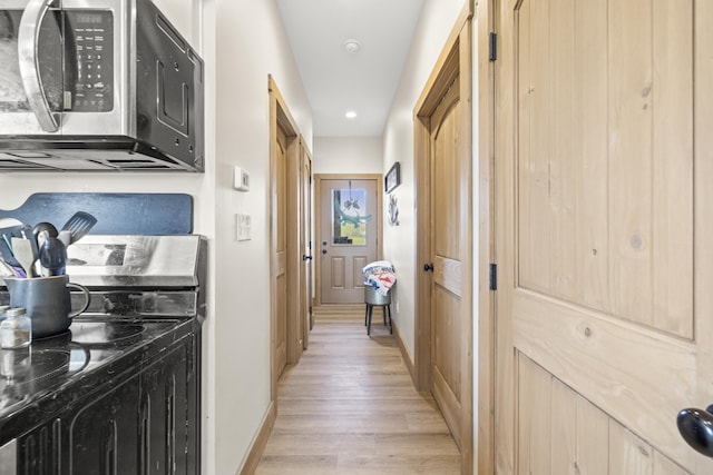 hall featuring recessed lighting, light wood finished floors, and baseboards