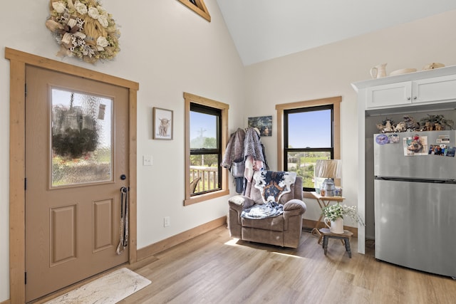 entrance foyer with a wealth of natural light, light wood-style floors, and high vaulted ceiling
