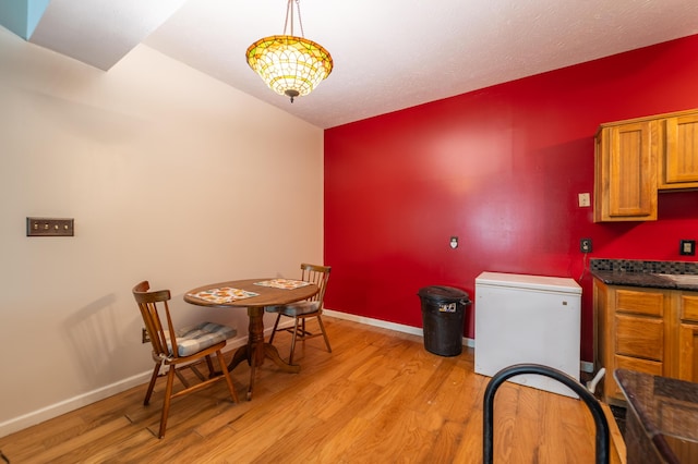 dining area featuring light wood-style floors and baseboards