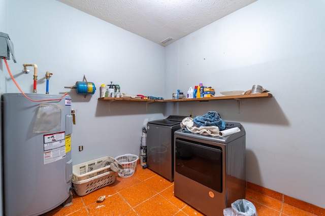 clothes washing area with washing machine and clothes dryer, a textured ceiling, laundry area, and electric water heater