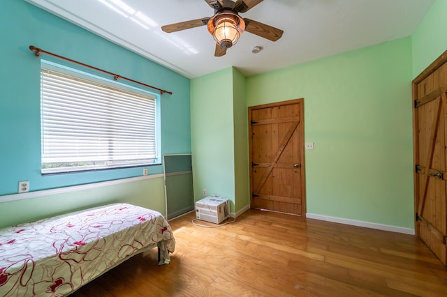 bedroom with baseboards, ceiling fan, and light wood finished floors