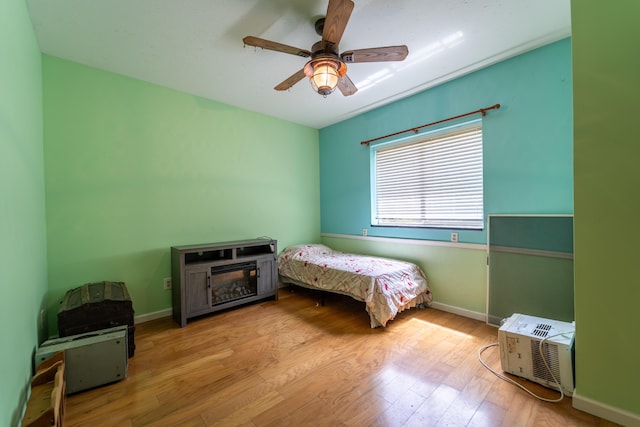 bedroom with baseboards, a ceiling fan, and wood finished floors