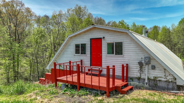 back of property with a deck and a gambrel roof