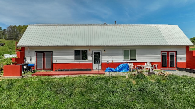 rear view of house with a yard and metal roof