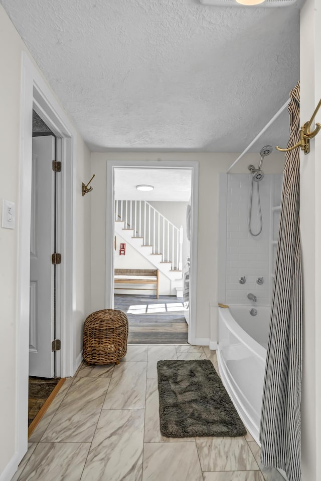 293 Deer Run Rd, Wellington, KY 40387 - bathroom featuring a textured ceiling,  shower combination, and marble look tile flooring