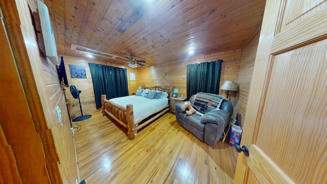 bedroom with wooden walls, wooden ceiling, ceiling fan, and hardwood / wood-style floors
