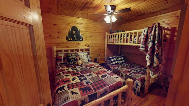bedroom with wood ceiling, ceiling fan, wood walls, and wood finished floors