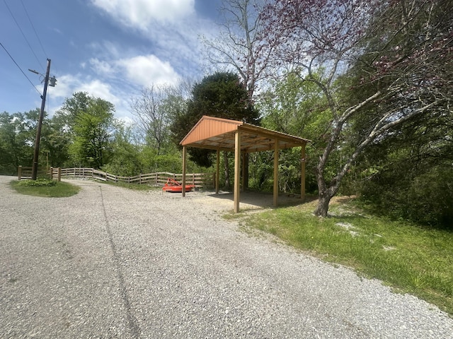 surrounding community with fence and a carport