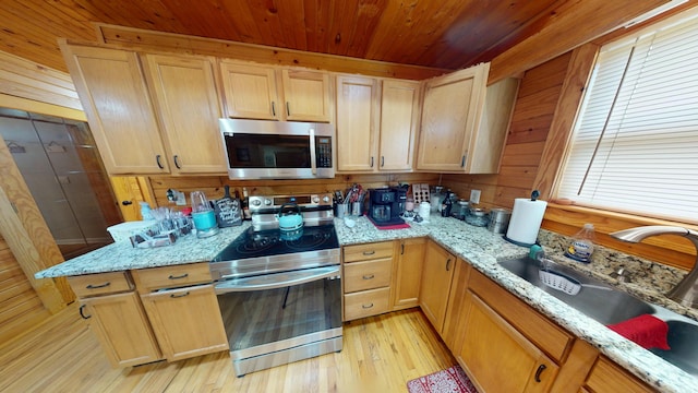 kitchen with a sink, light stone counters, wooden ceiling, light wood finished floors, and stainless steel appliances