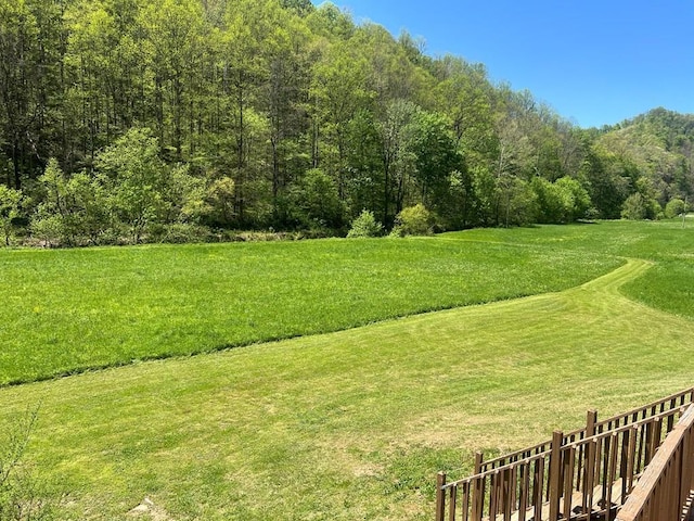 view of home's community featuring a lawn and a forest view