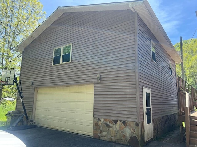 view of property exterior featuring a garage and stairs