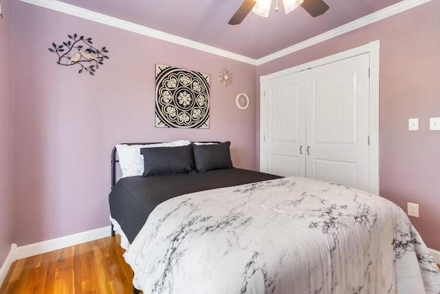 bedroom featuring a closet, baseboards, light wood-type flooring, a ceiling fan, and crown molding