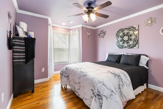bedroom featuring baseboards, visible vents, ornamental molding, and light wood-style flooring