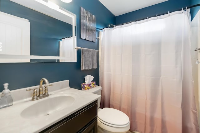 bathroom featuring toilet, curtained shower, and vanity