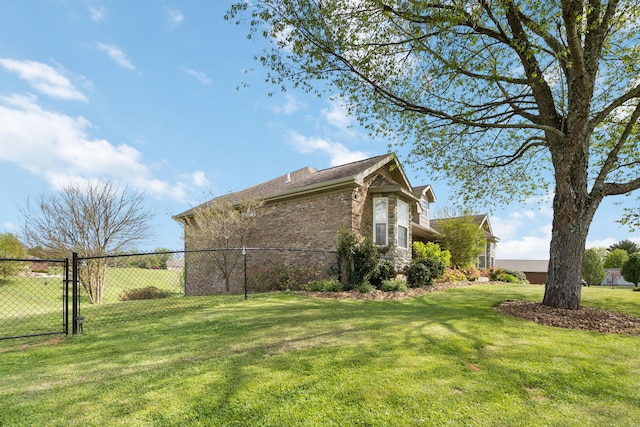 view of property exterior featuring a gate, brick siding, fence, and a lawn