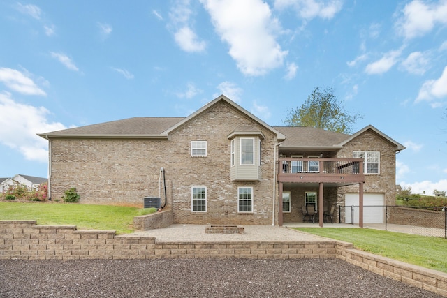 rear view of house with brick siding, a lawn, a garage, and a patio area