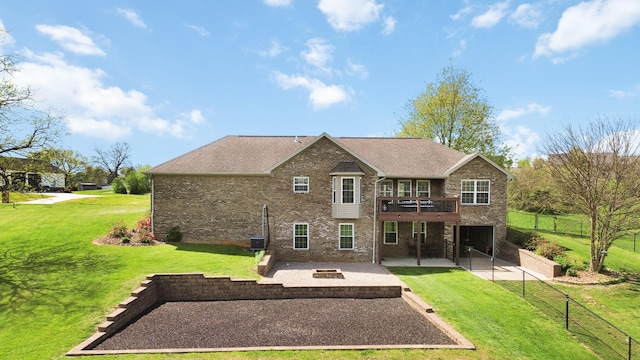 back of house featuring an outdoor fire pit, a yard, brick siding, a wooden deck, and a patio area