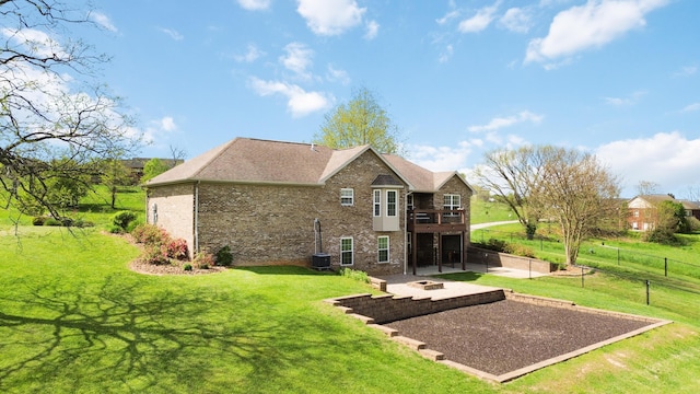 rear view of house featuring a lawn, a fire pit, brick siding, and a patio area