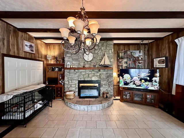 living area with wooden walls, beamed ceiling, a fireplace, and a chandelier