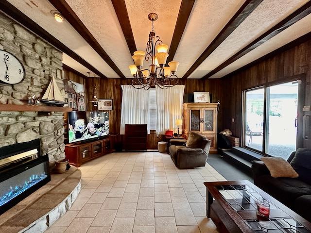 living room featuring wooden walls, an inviting chandelier, beam ceiling, and a fireplace